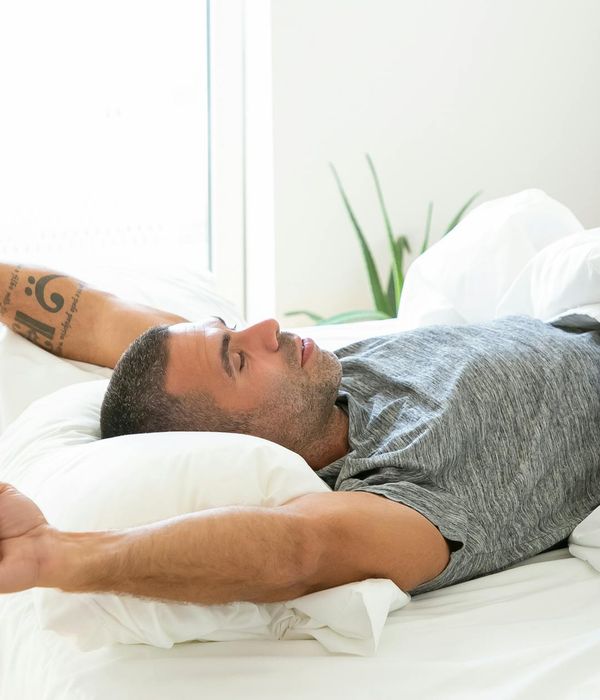 Man stretching gently by a window with morning light.